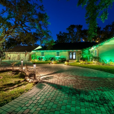 Permanent roofline lighting in green for St. Patrick&rsquo;s day with bollard lighting along the dri Photo