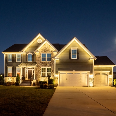 Warm white permanent roofline lighting shows this home&rsquo;s architectural features Photo