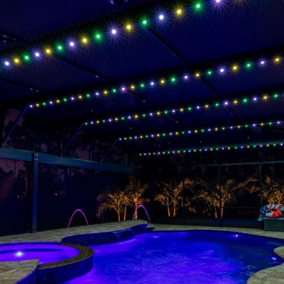 Permanent roofline lighting over a pool in a lanai can be changed for any holiday, like Mardi Gras.  Photo