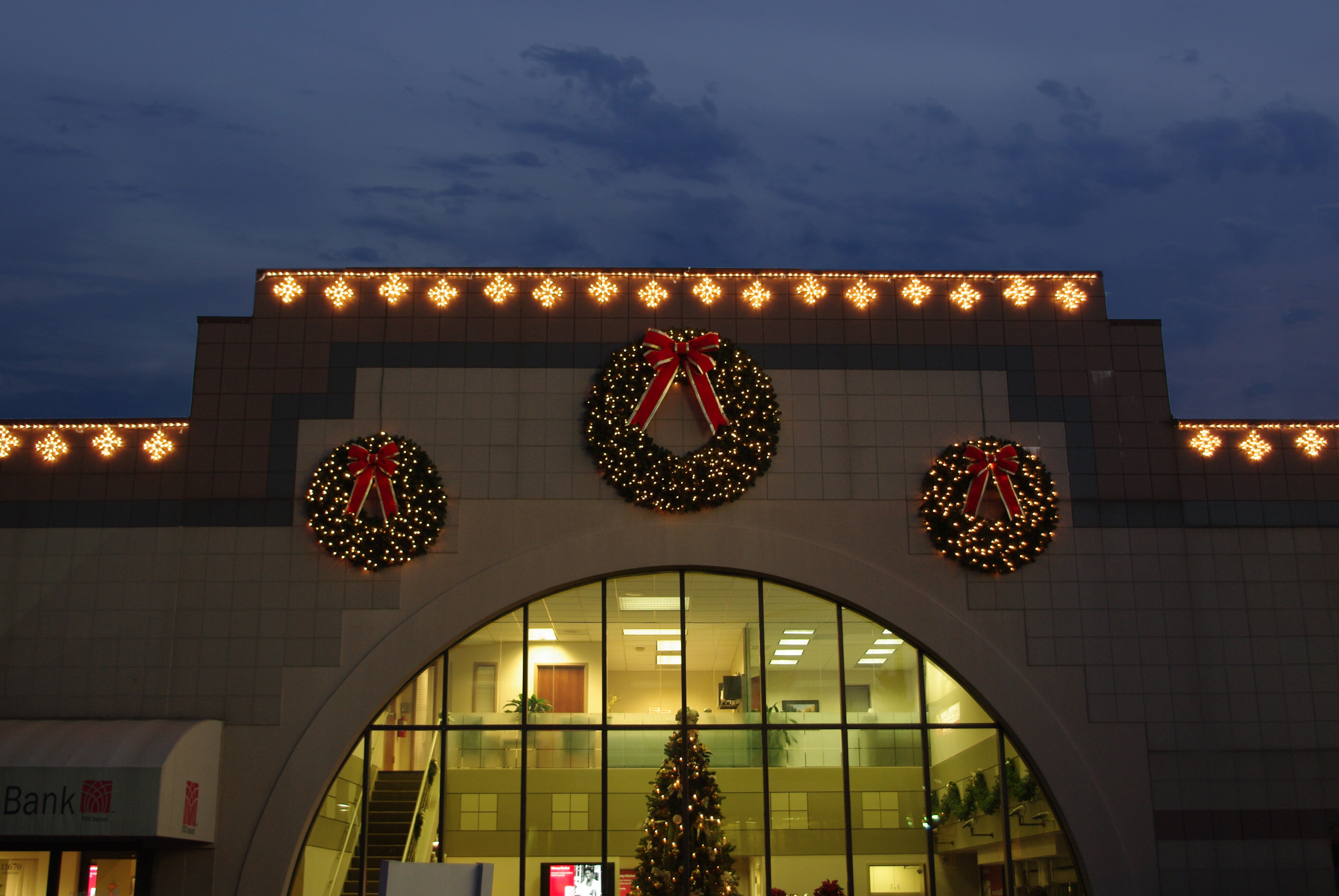 commercial property with holiday wreath and light display