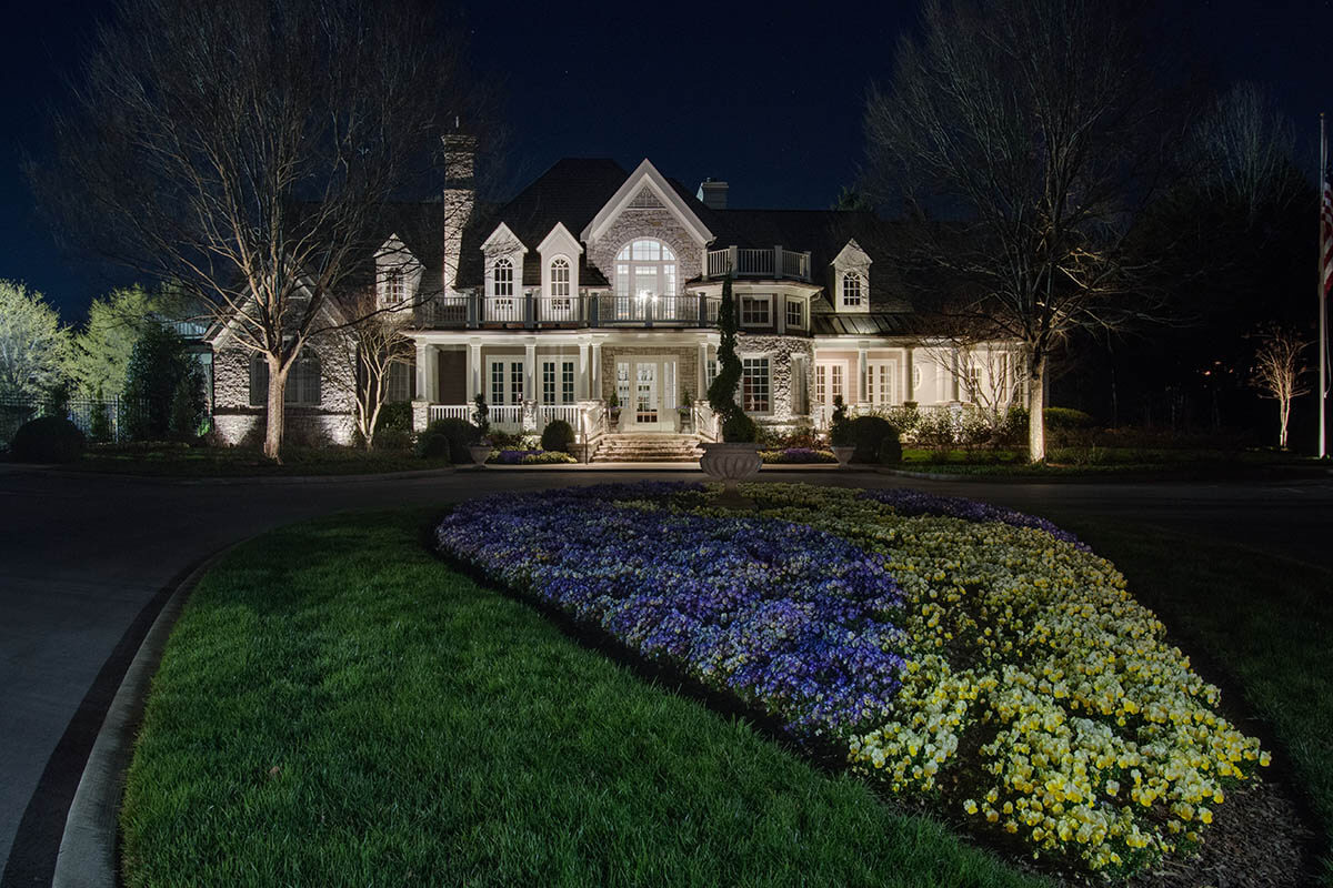 Well lit house and flowerbed 