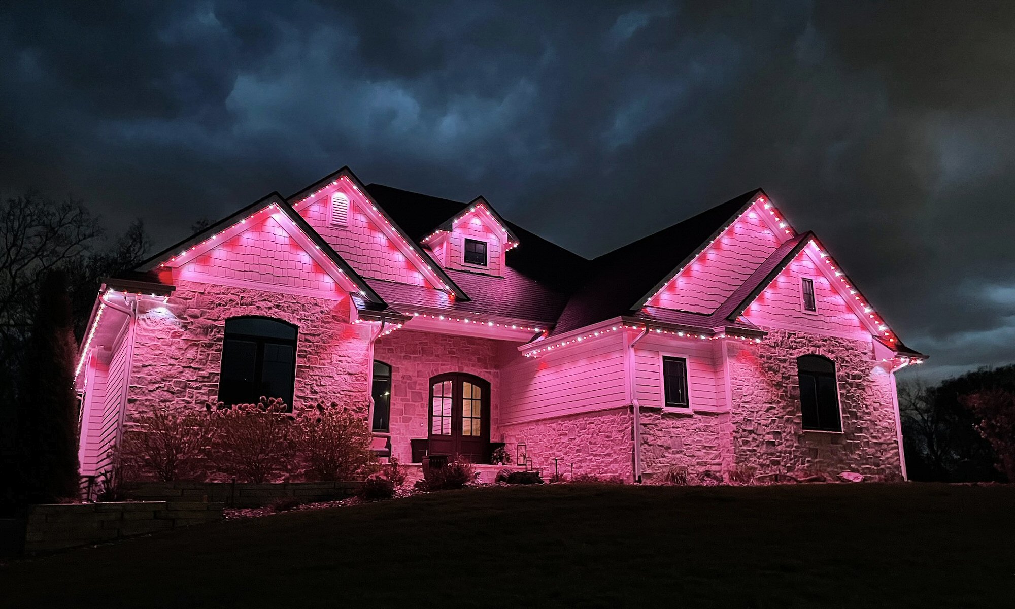 Permanent roofline lighting displaying red and white holiday lighting on a Johnston Iowa home