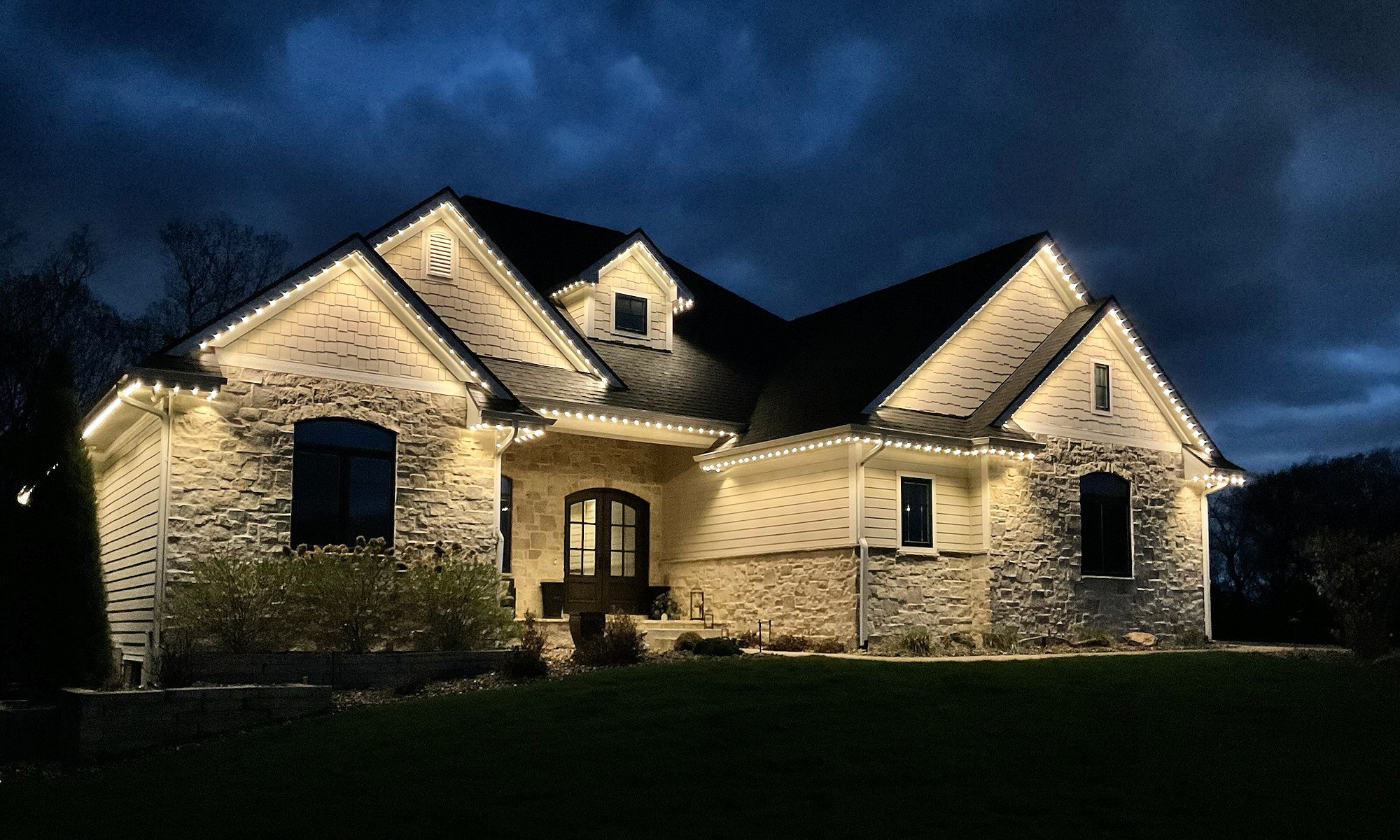 Warm white permanent roofline lighting installed on a Johnston Iowa home