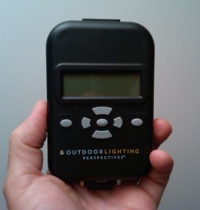 Person holding an OLD outdoor light timer in their hand