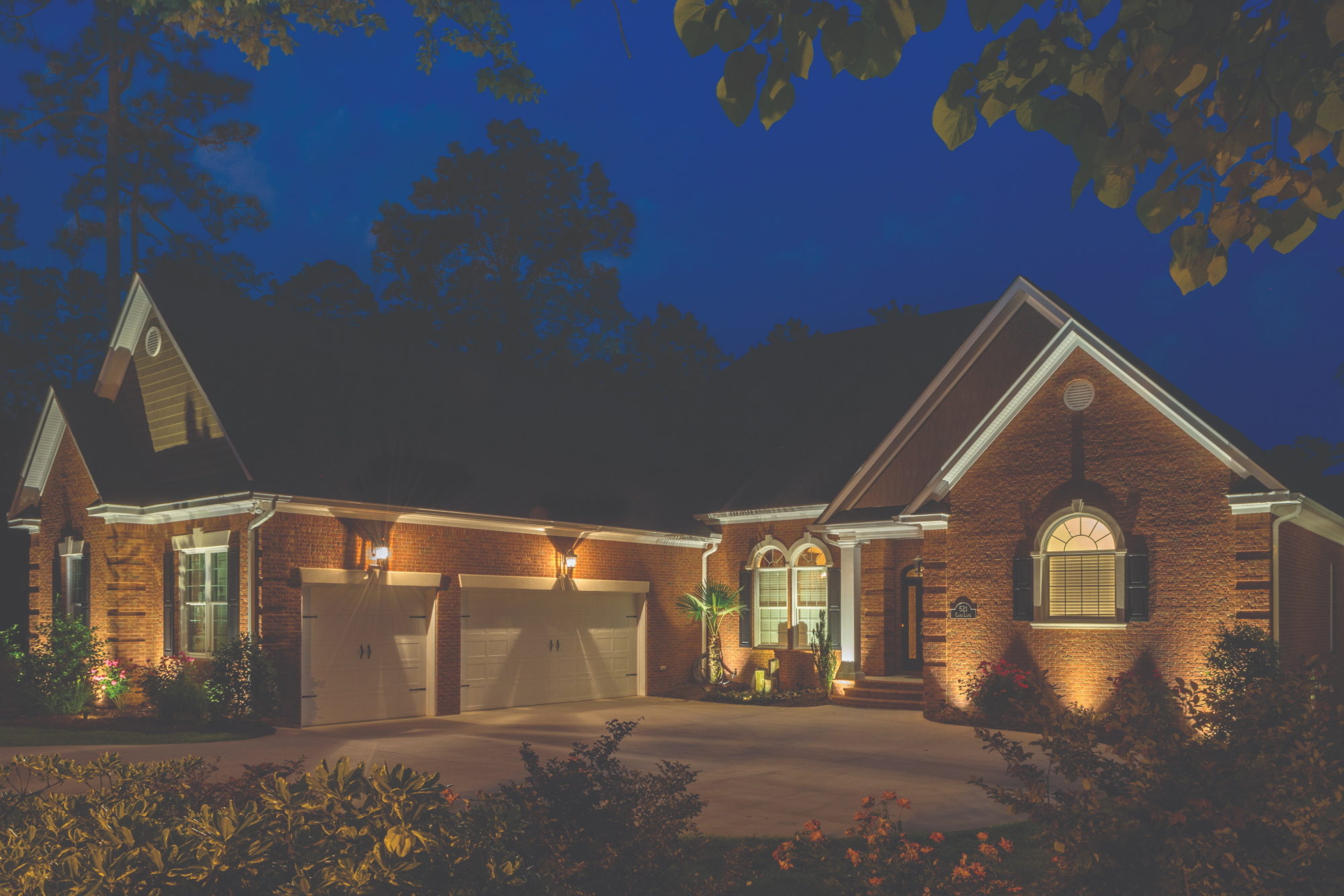 front of a home lit up with outdoor lighting