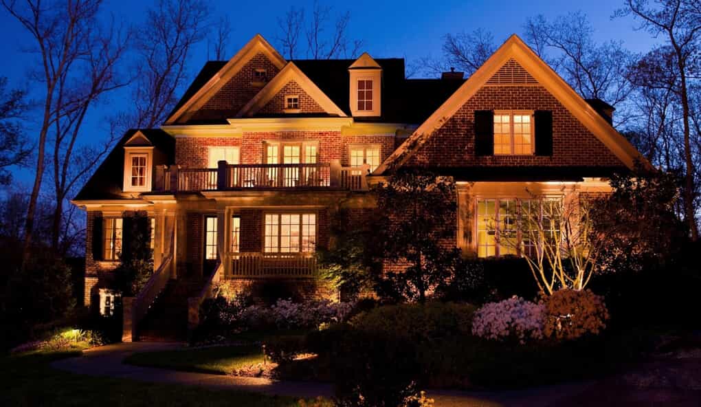 large home with illuminating lights on the house