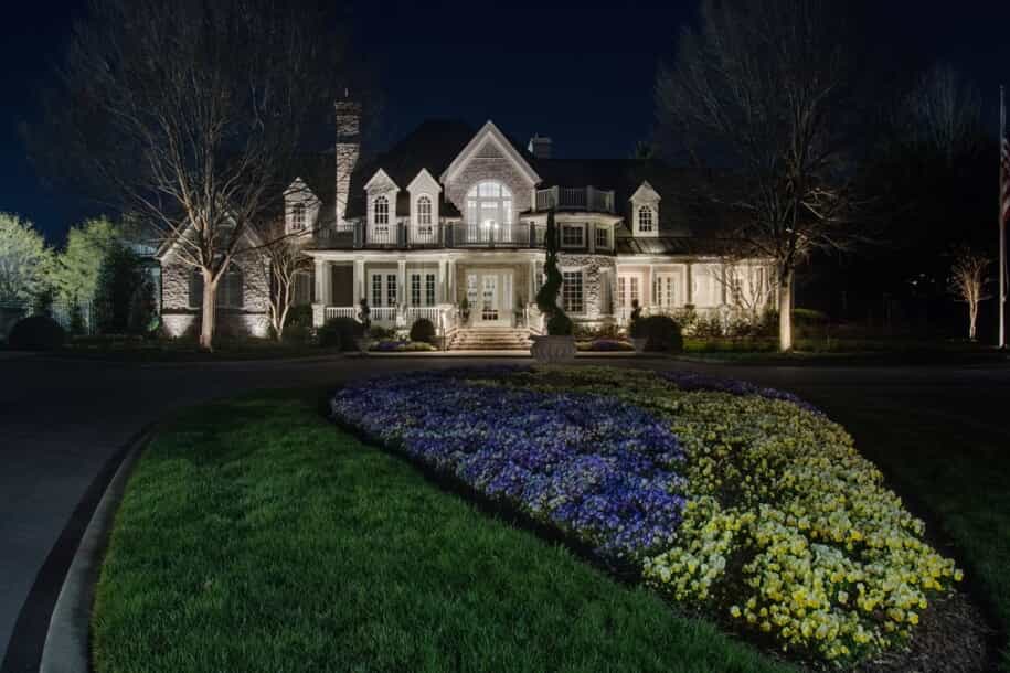 front yard image of home at night with illumination lighting 