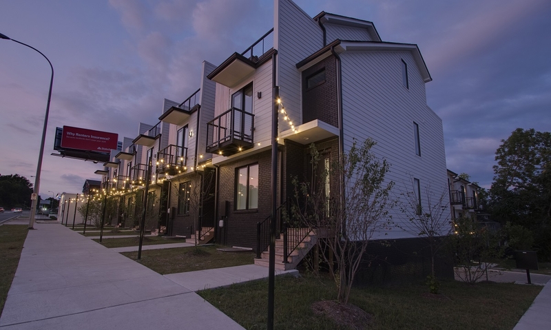 Overhead string lighting in front a row of townhomes