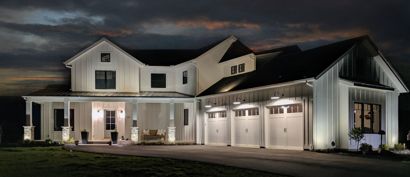 two-story barn-style house lit at night