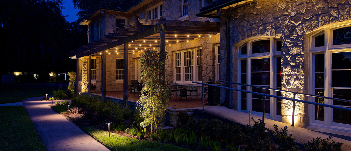 A house with lights on the porchDescription automatically generated