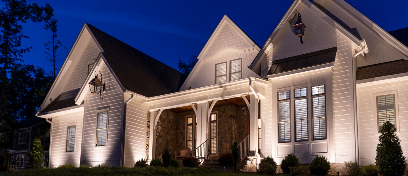 A house with lights on the frontDescription automatically generated
