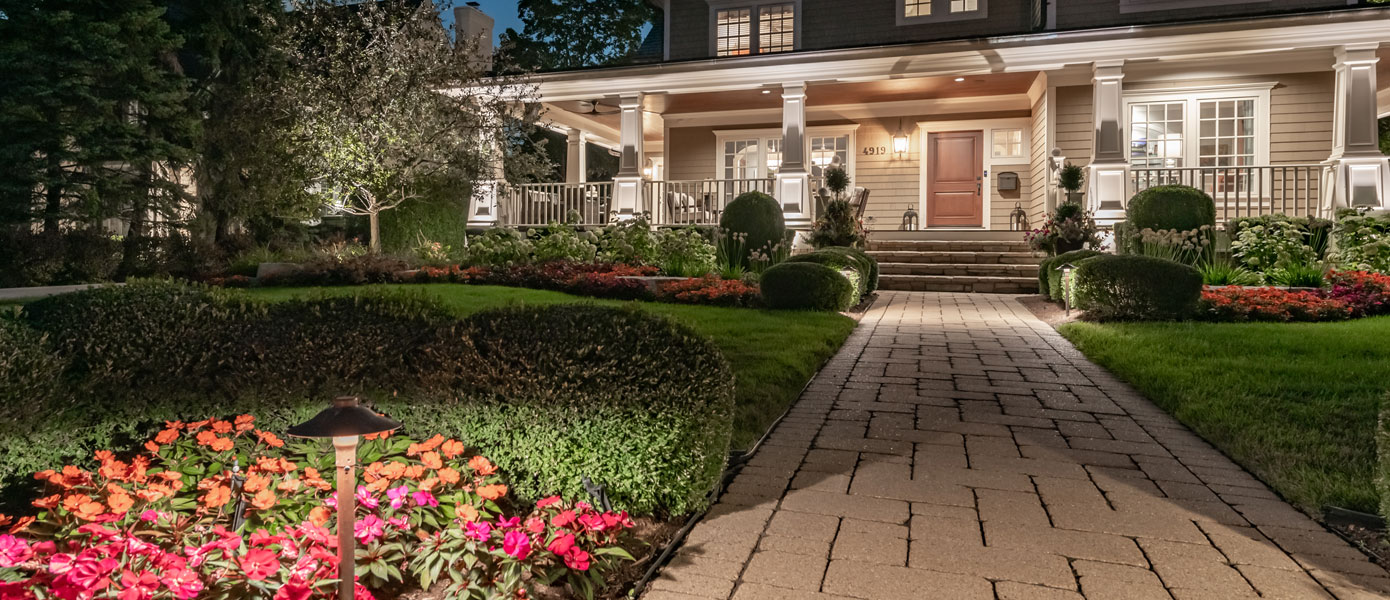 A brick walkway leading to a houseDescription automatically generated