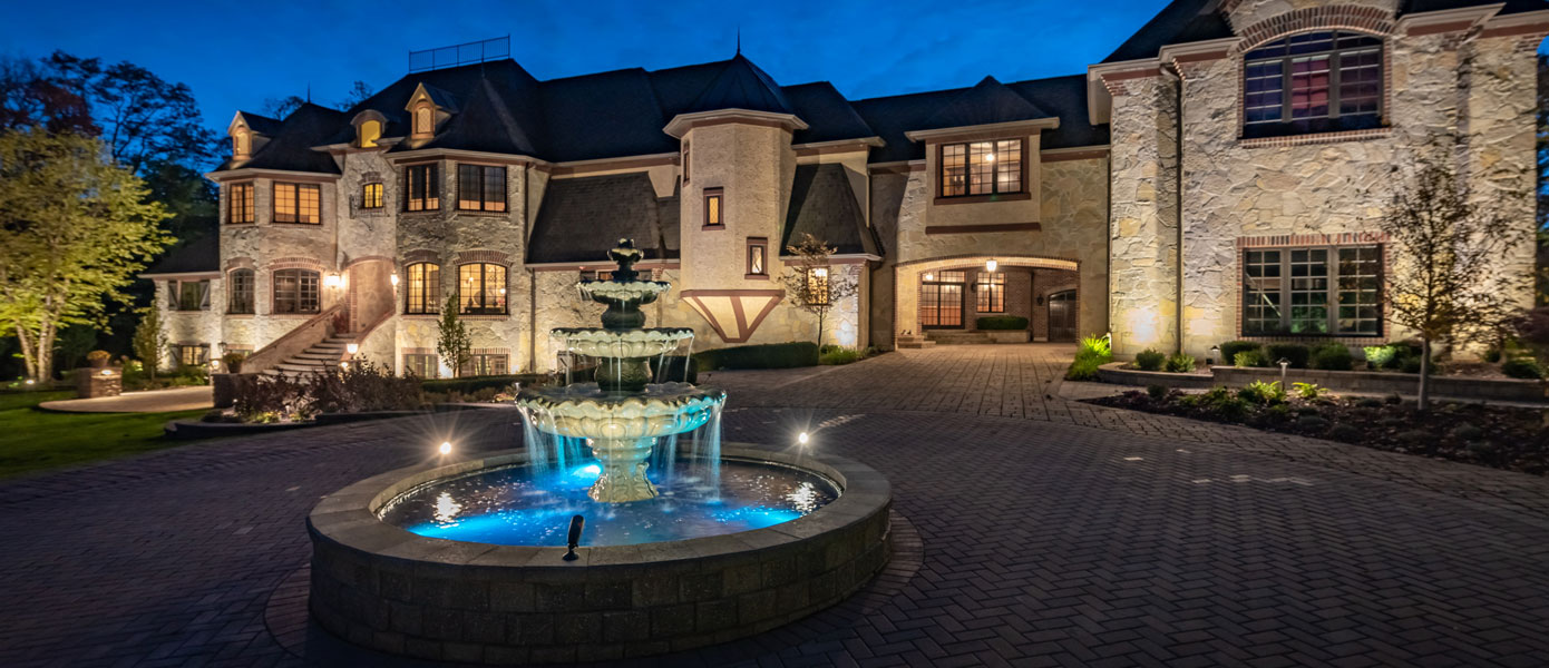 A fountain in front of a house

Description automatically generated