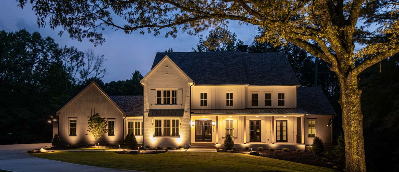 A large white house with lights on