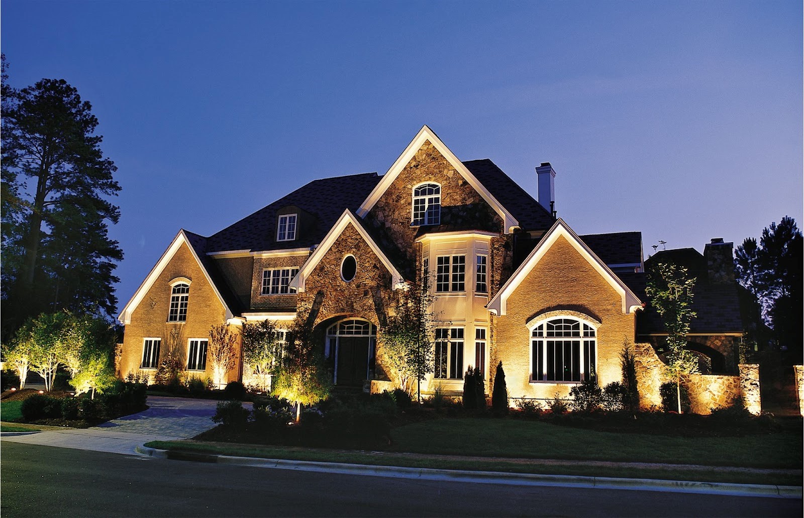 Landscape Lighting Used To Brighten Trees, Gardens, Pathways, and Front Facade of Home