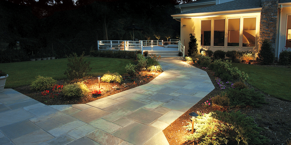 Pathway leading to a residential deck that has special lighting