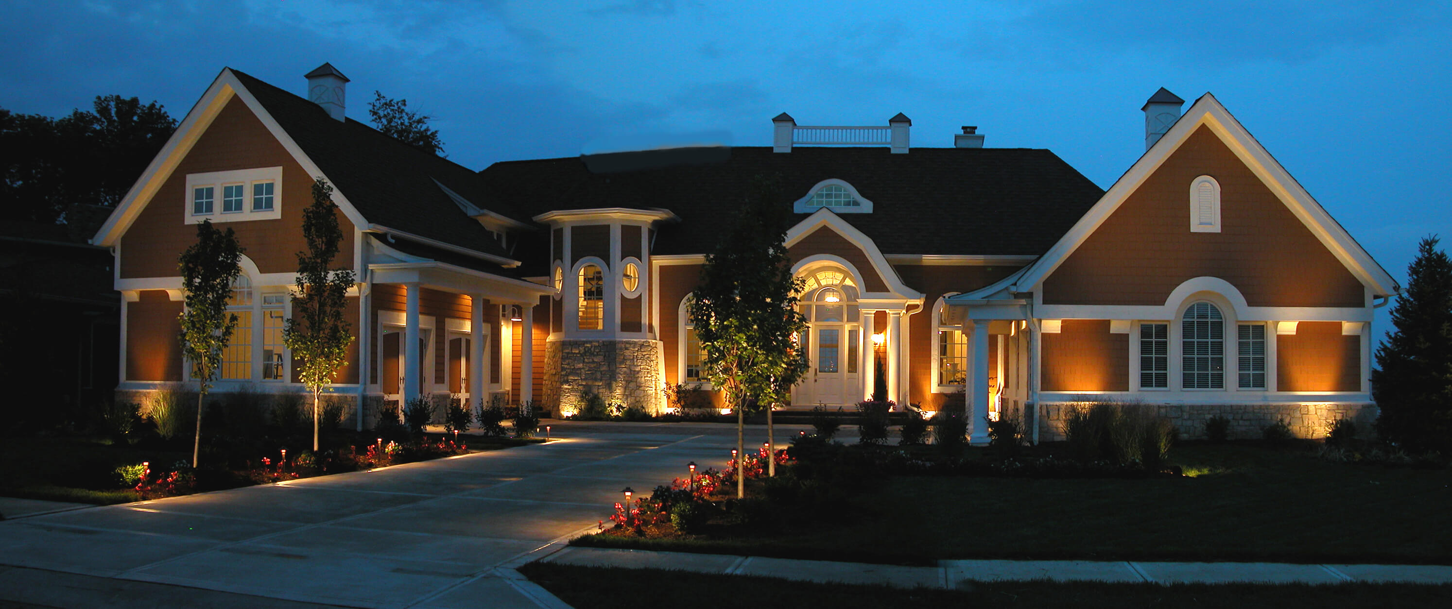 Red and white building and driveway that has specialty lighting