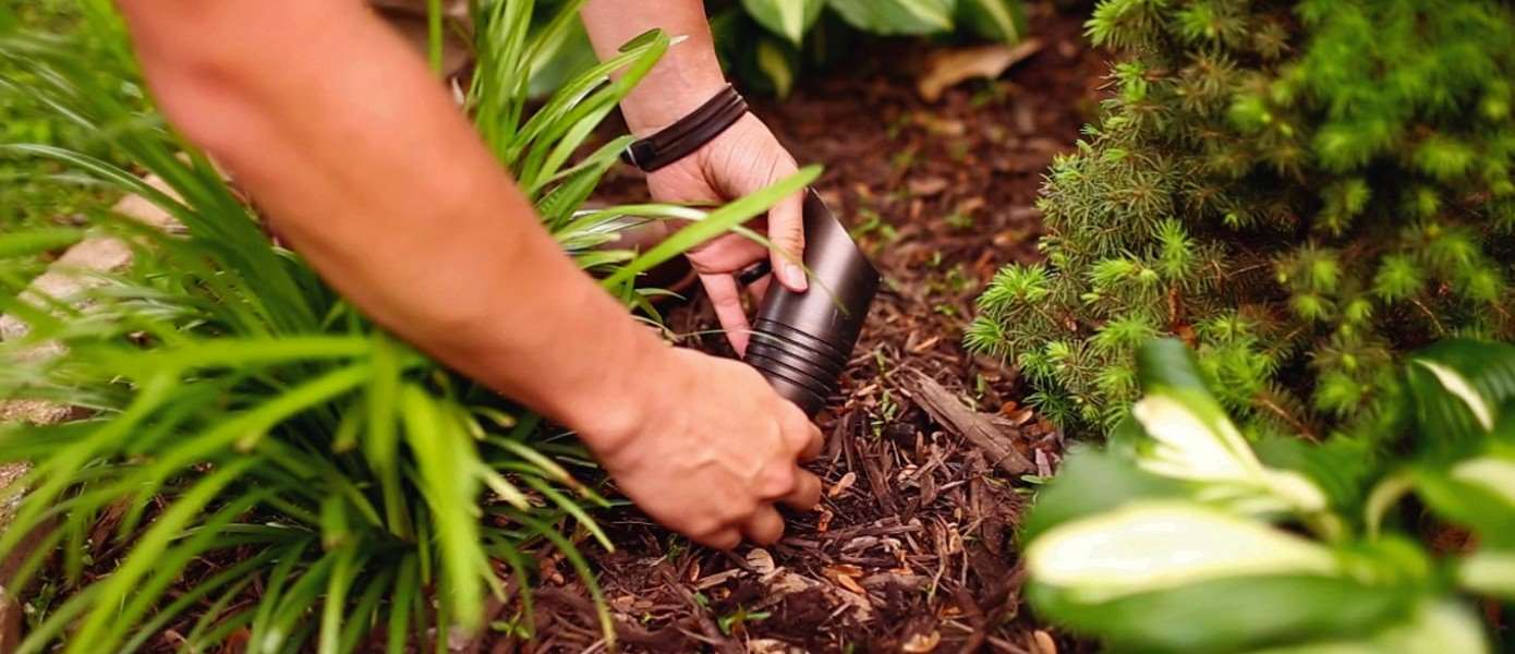 two hands fixing an outdoor lawn light