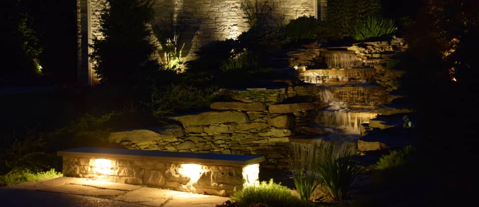 Residential water fountain with illumination lighting in a backyard