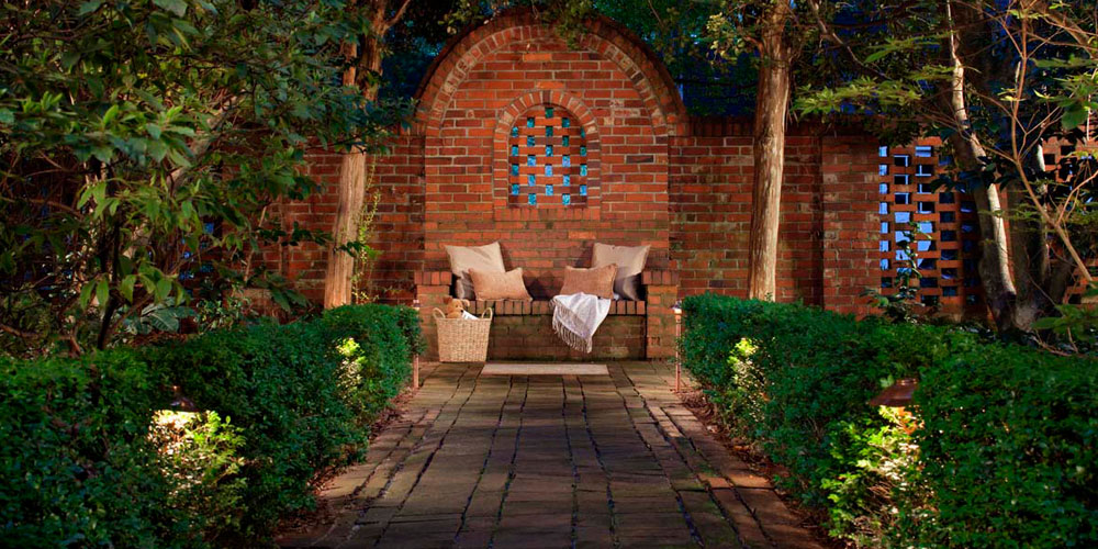 Brick patio with a bench and specialty lighting