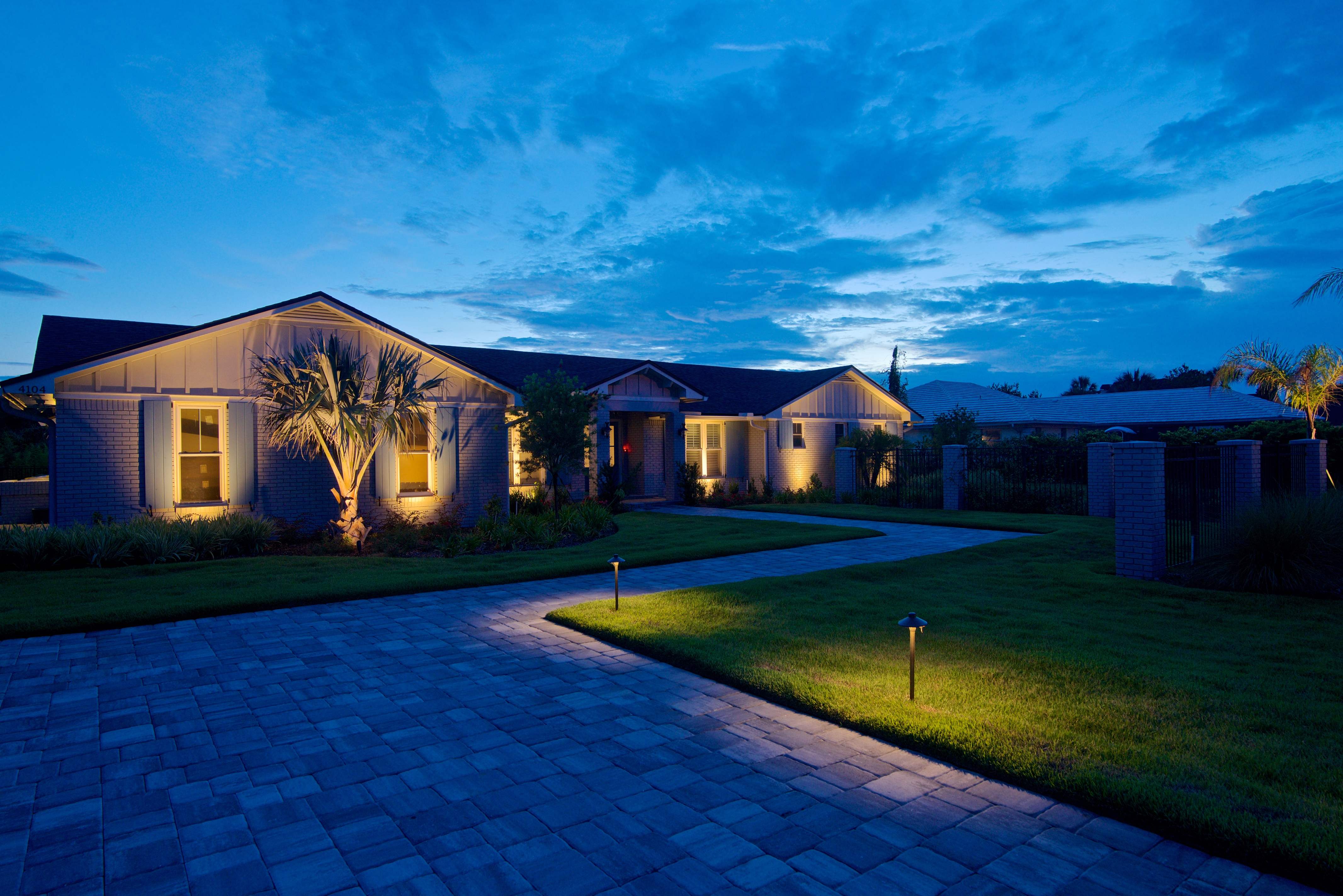A house with a driveway and lawnDescription automatically generated