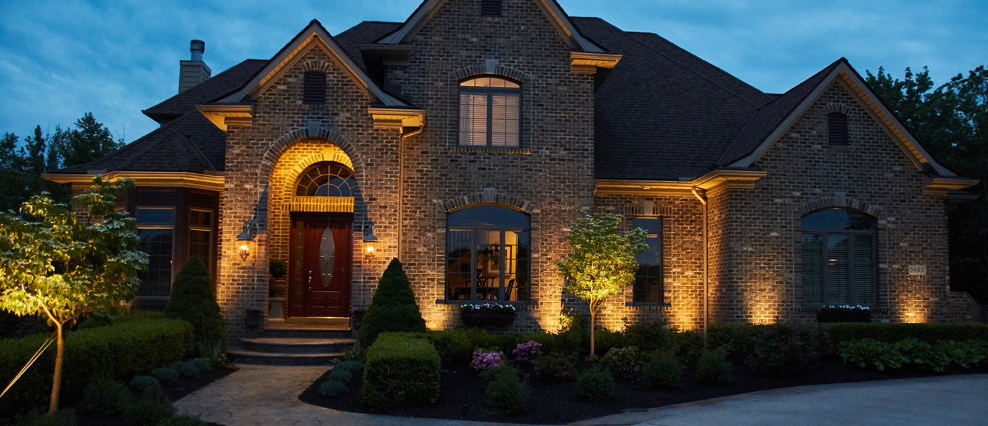 architectural lighting of a brick house and surrounding plants