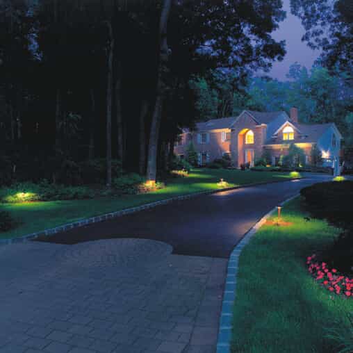 Driveway and home with beautiful outdoor lighting