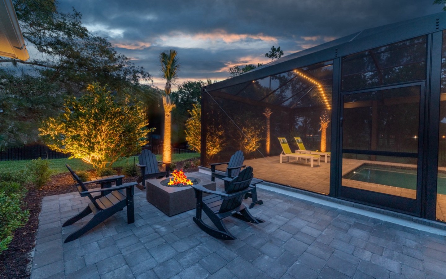 A patio with chairs and a fire pit

Description automatically generated