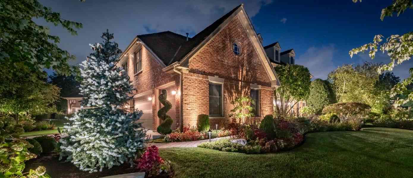 outside of a brick house illuminated by outdoor lighting