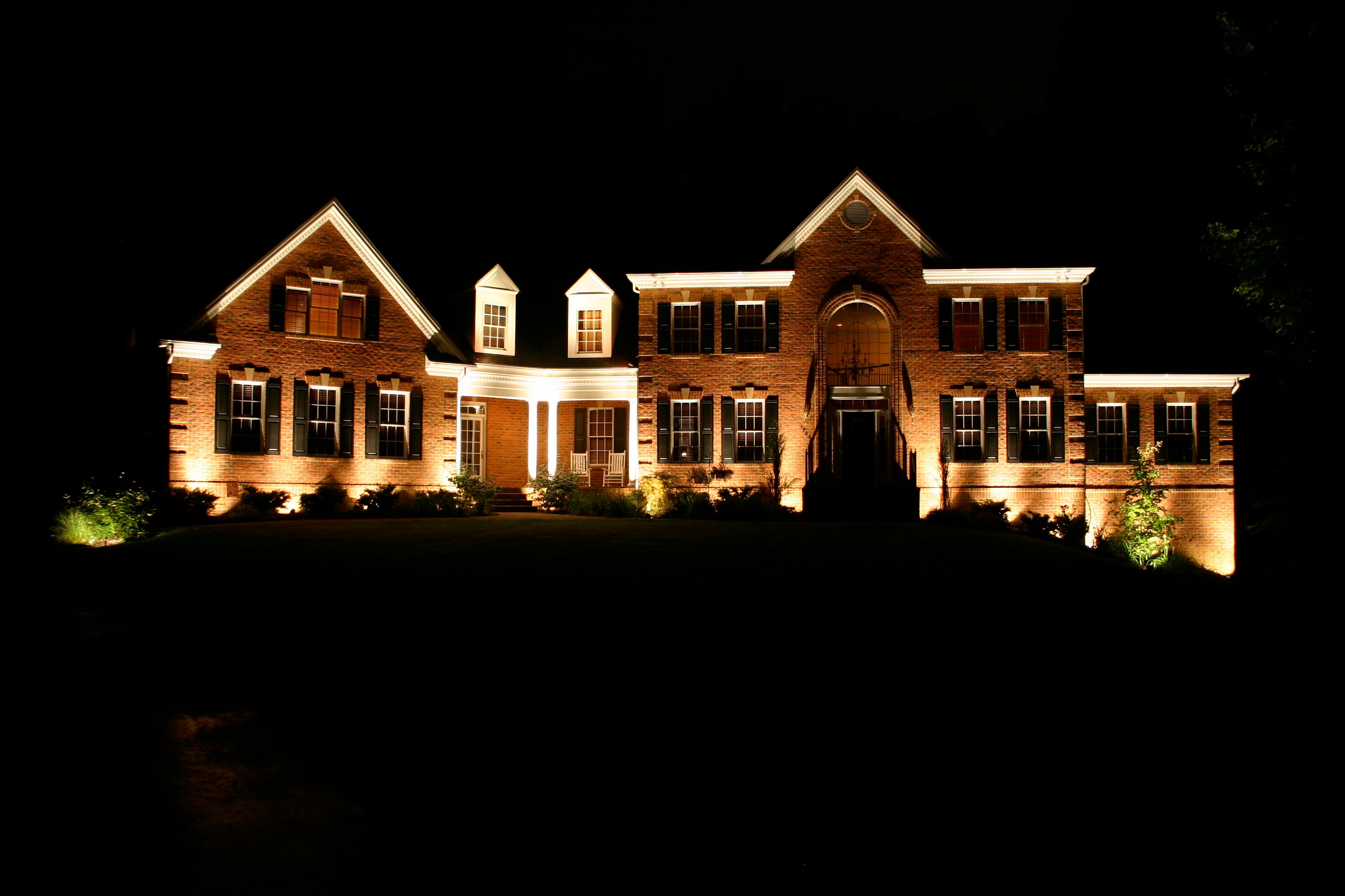 Wide shot of a home with beautiful outdoor lighting