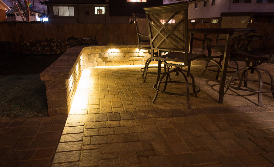 Outdoor stone patio with a table and chairs and special lighting
