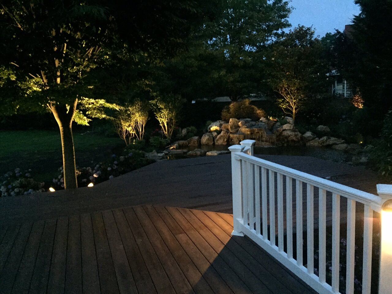 Deck with trees and a white gate around it
