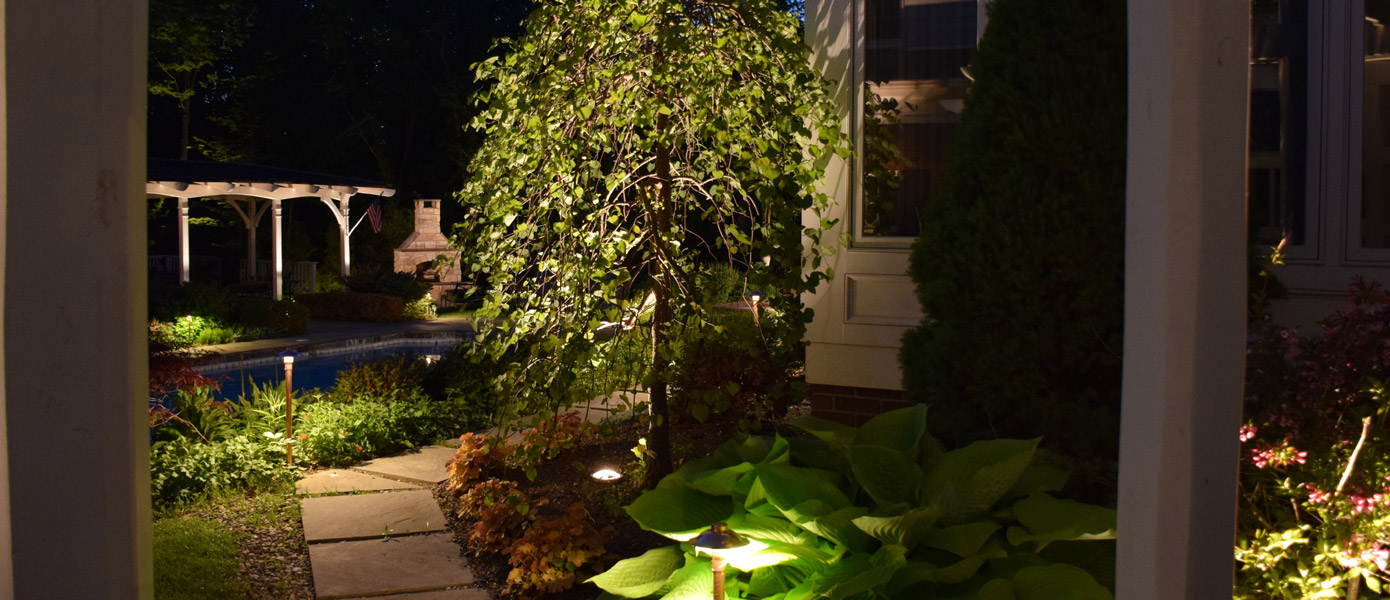 landscape lighting illuminating backyard pathway outside of East Memphis home