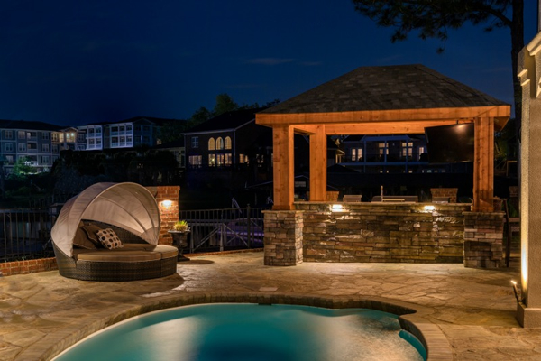 pool, chairs, and outdoor bar lit with OLP lighting 