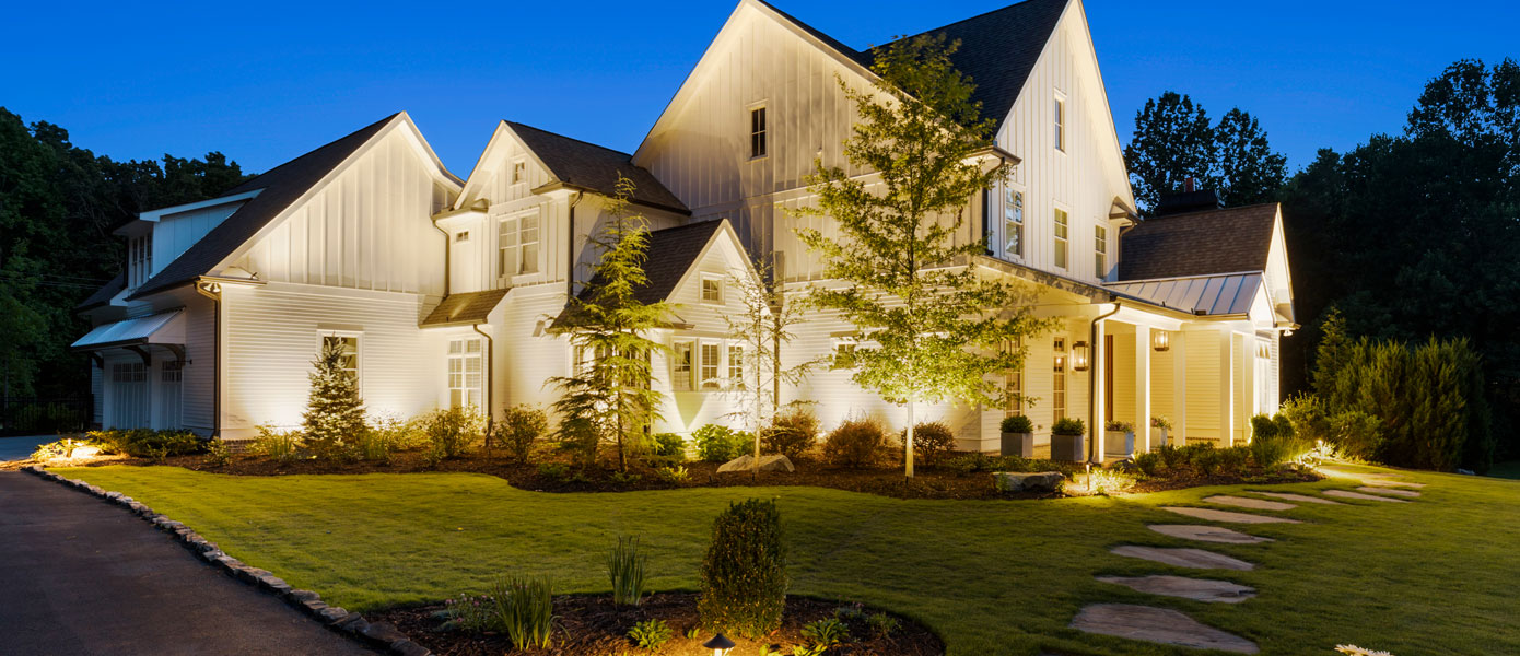A large house with a lawn and treesDescription automatically generated