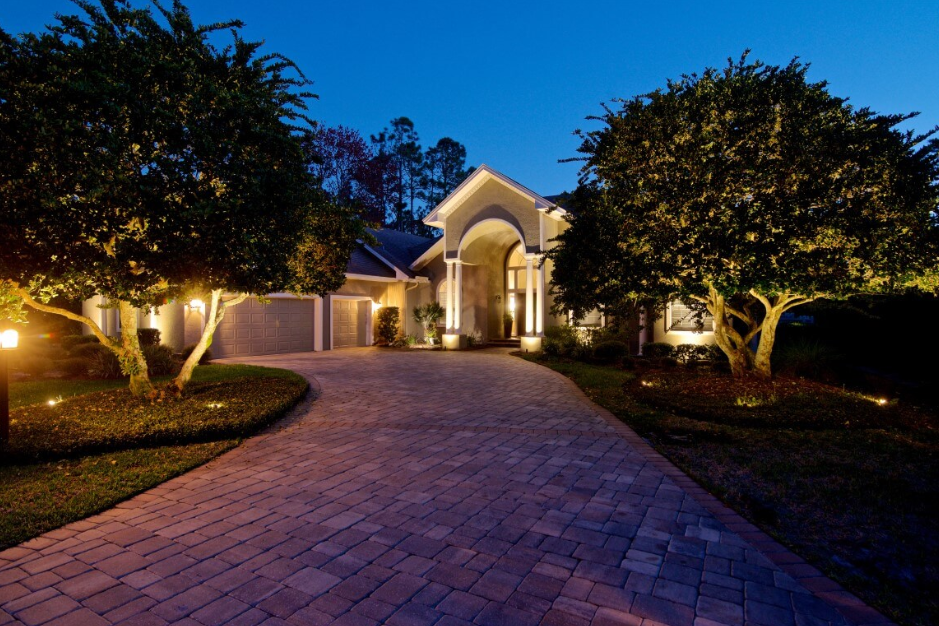 exterior lighting of a house and drive way as well as landscape lighting on trees