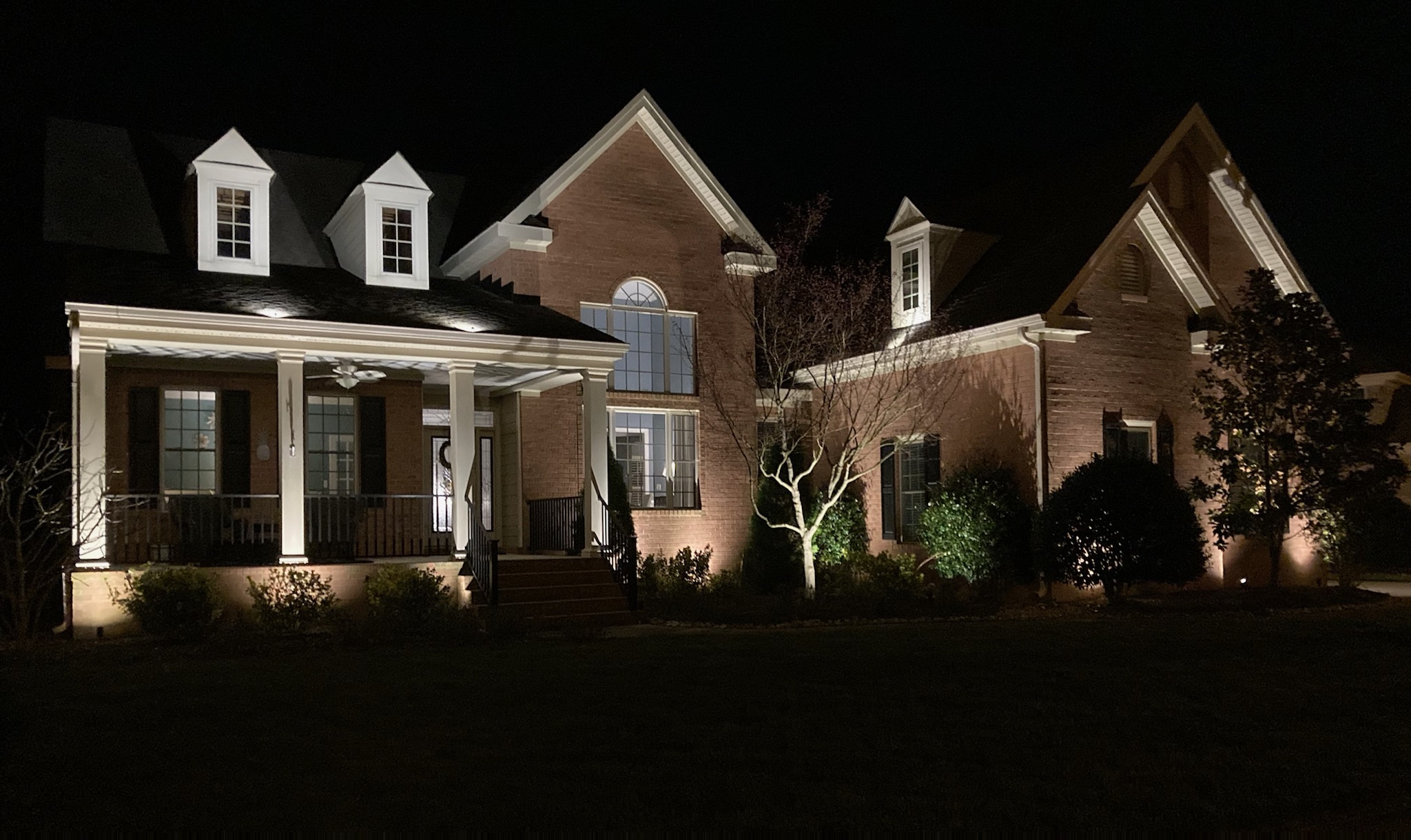 brick home with exterior lighting