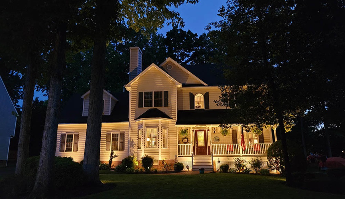 A house with trees in the front at night