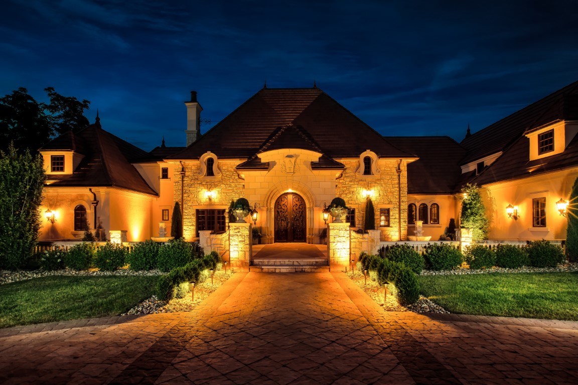 A house with lights on the frontDescription automatically generated