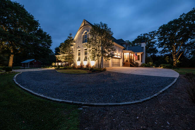 A house showing the garage and driveway with exterior home lighting in Atlanta