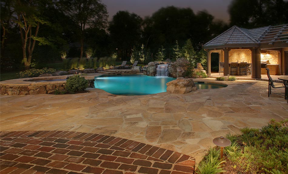 Outdoor pool and deck with with a lounge area and special lighting