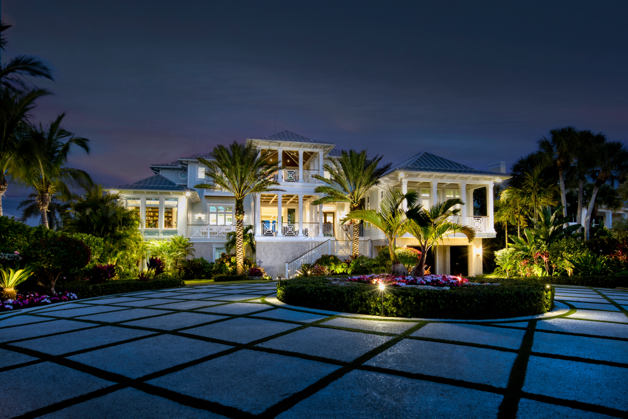 exterior of home lit up with palm trees