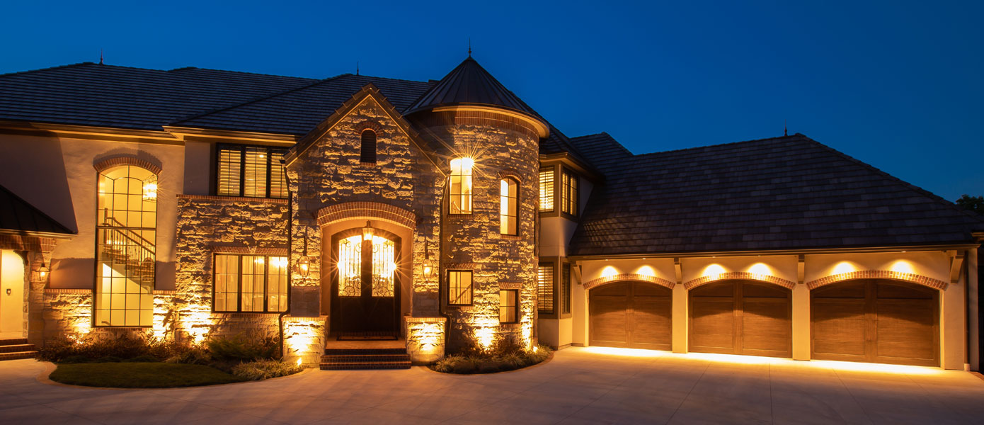 A house with lights on the frontDescription automatically generated