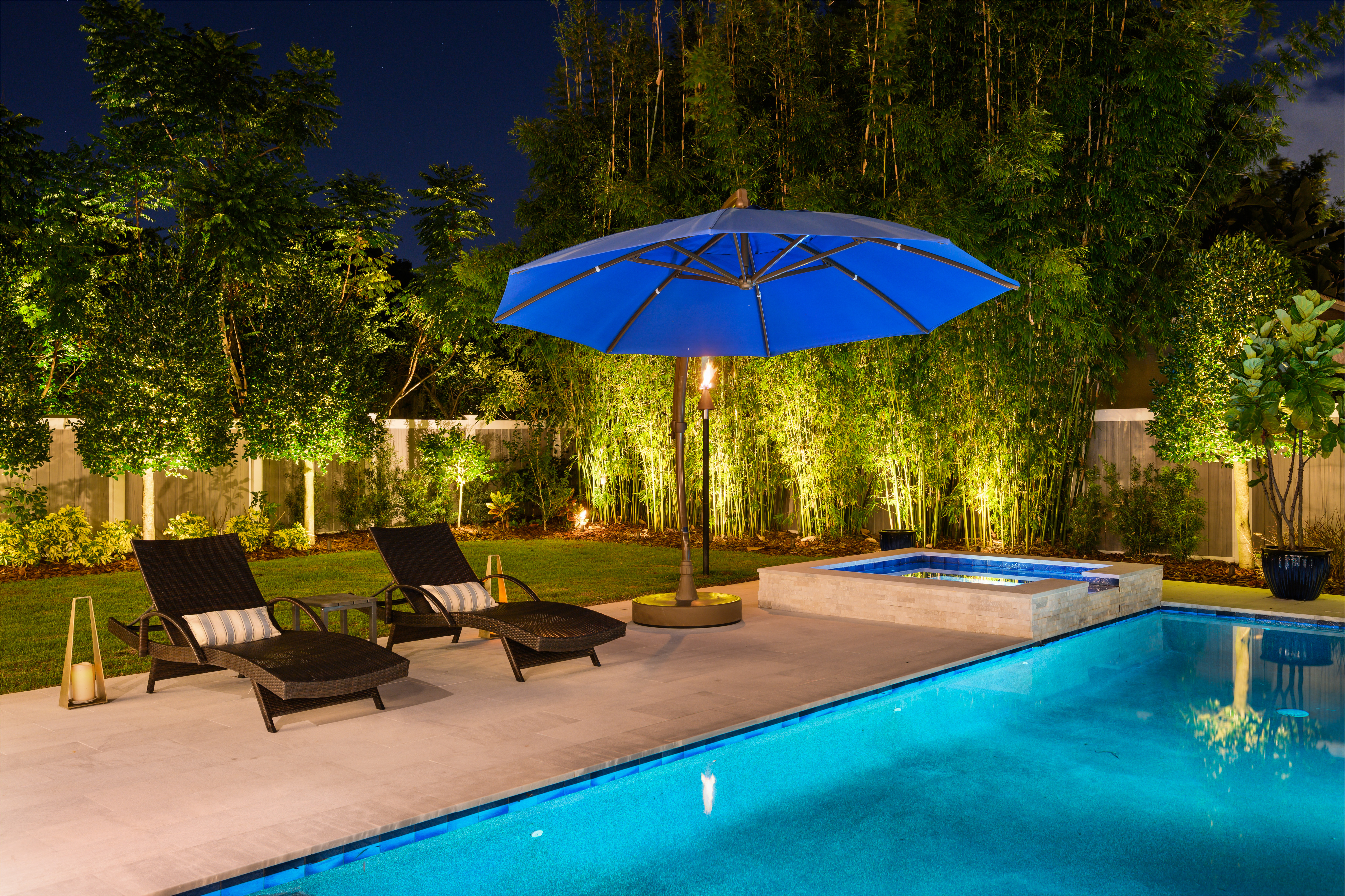 exterior of backyard and pool lit up