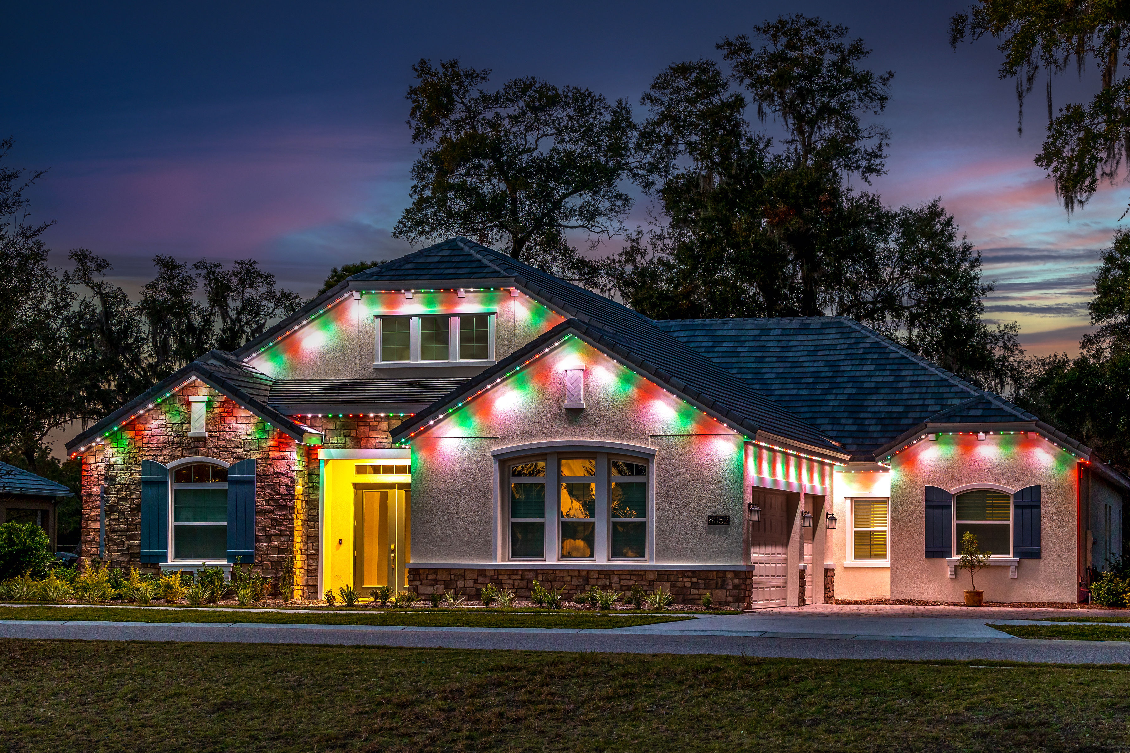 home with multicolor lights red, green, and white Christmas lights on house